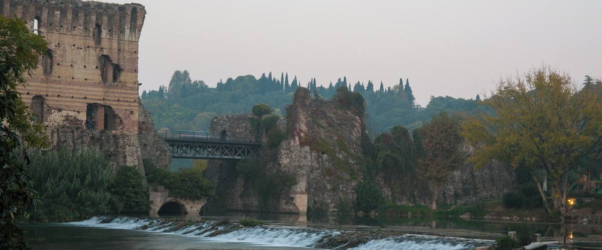 A river with a bridge and ancient ruins.