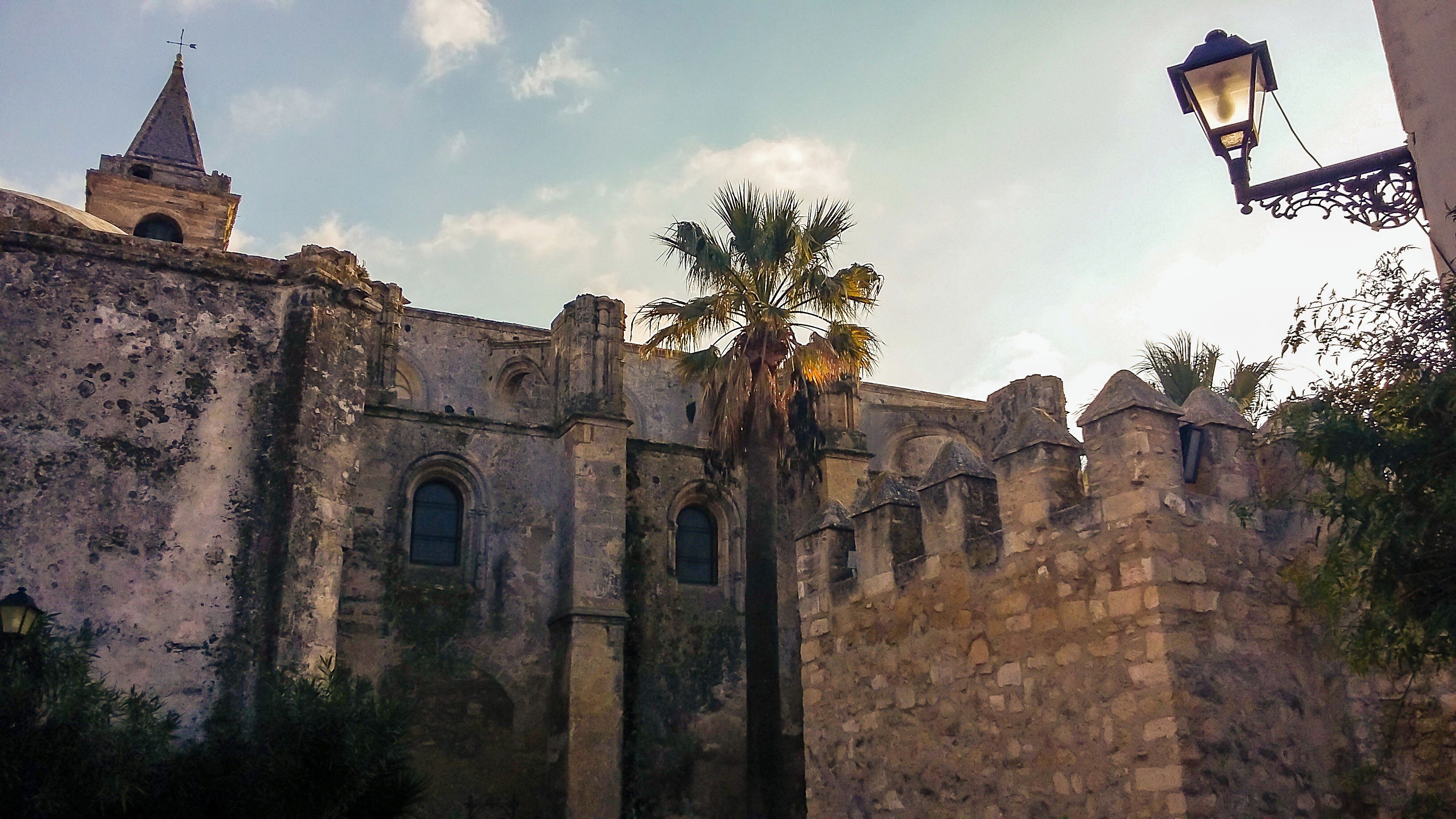 An old stone building with arched windows and a tower.