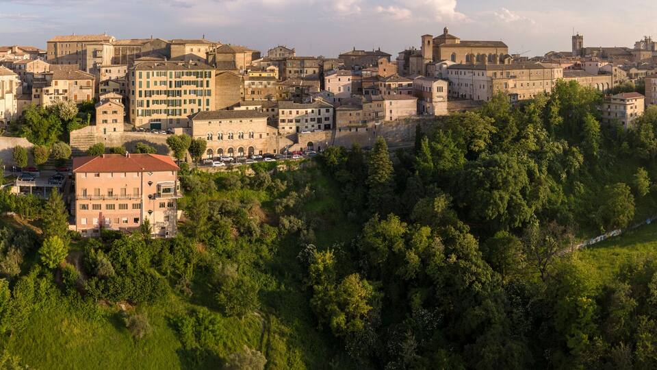 A historic town with dense tree coverage and a prominent church.