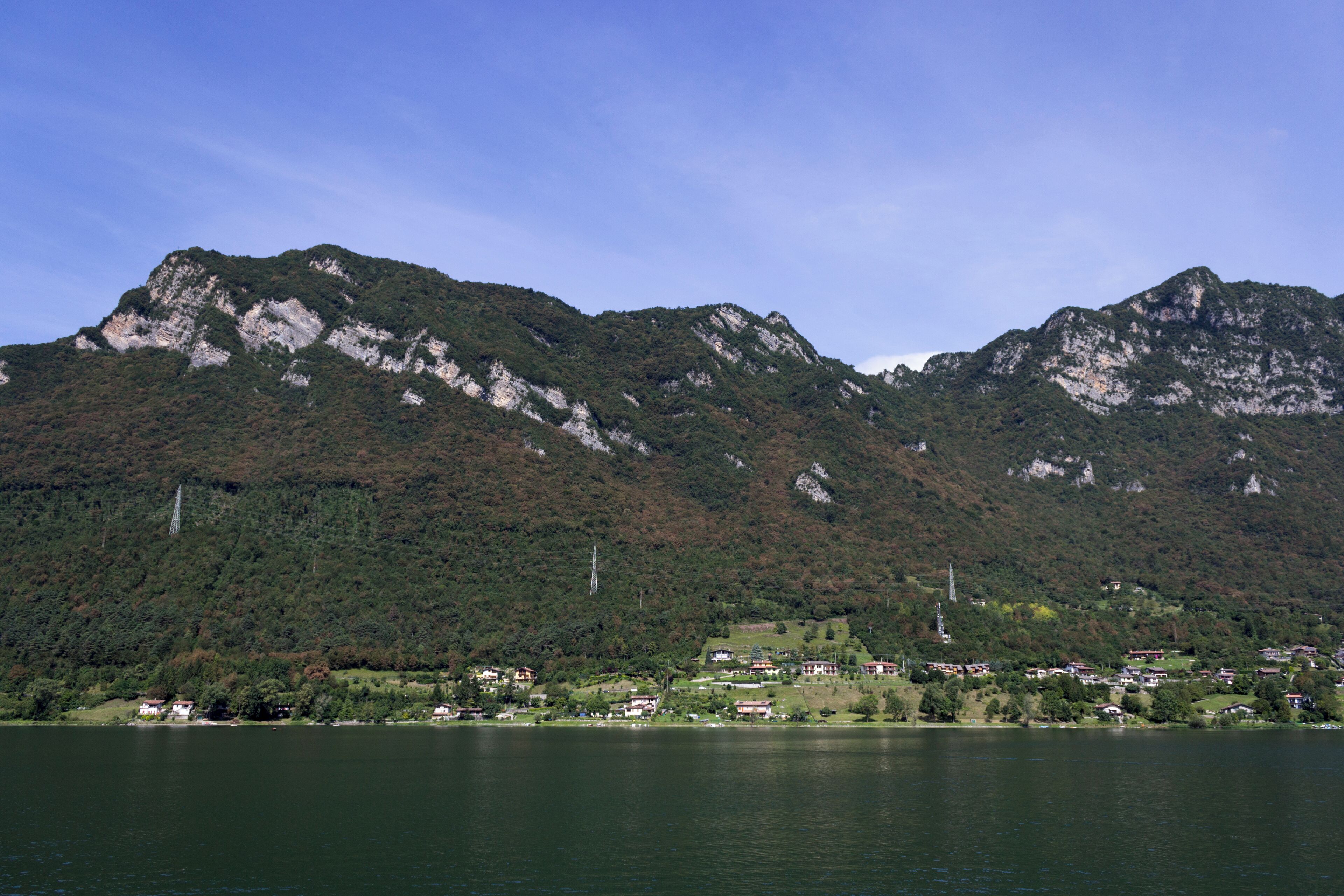A lake with mountains in the background and a small village in the foreground.