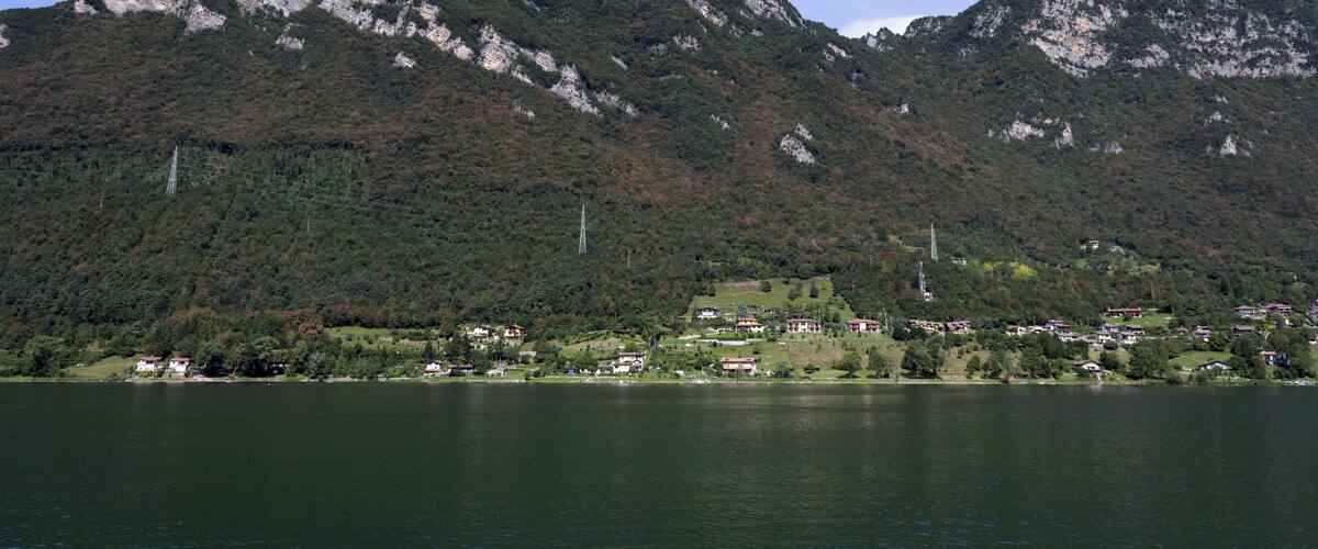 A lake with mountains in the background and a small village in the foreground.