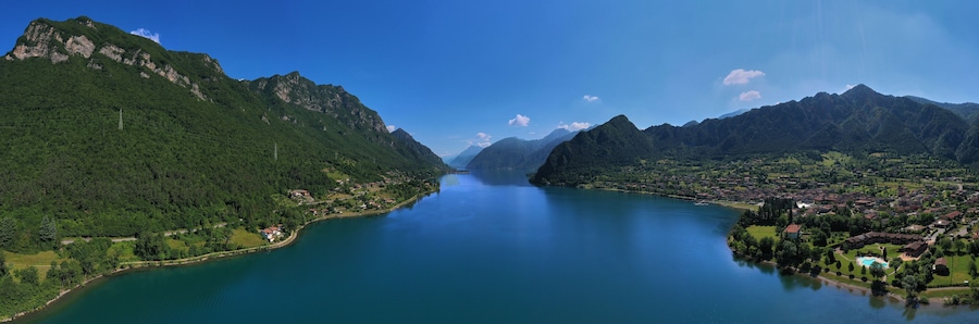 Un lago rodeado de montañas, un pueblo pequeño y un cielo despejado.