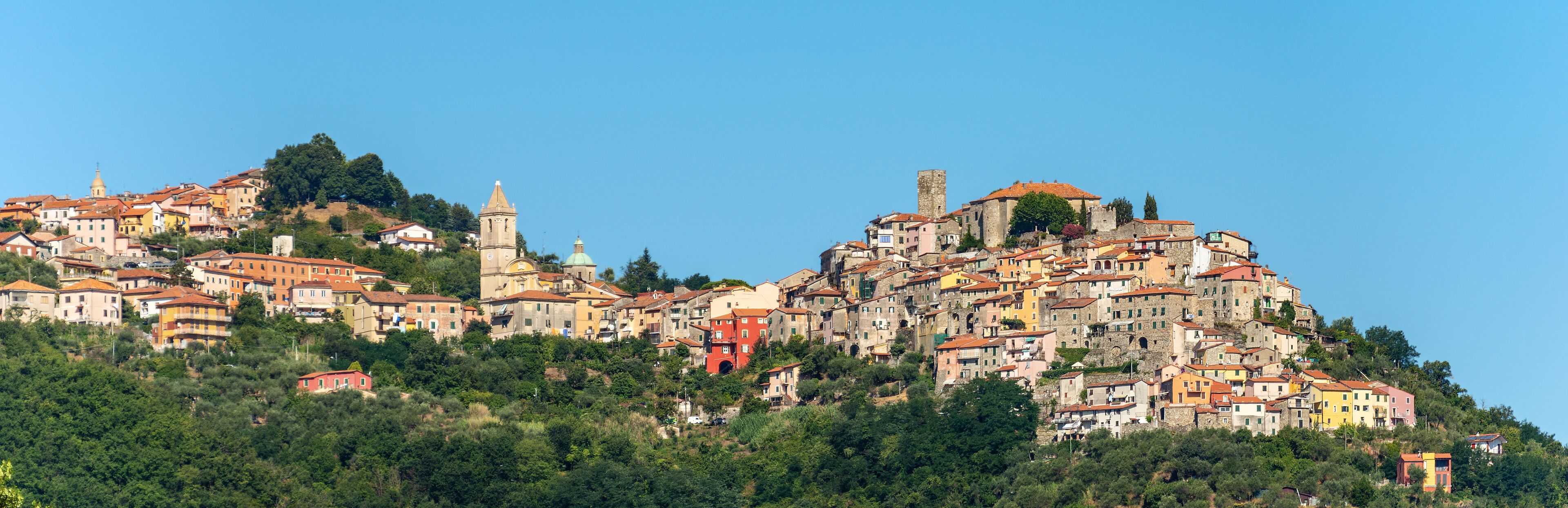 A hillside town with historic buildings and a prominent church tower.