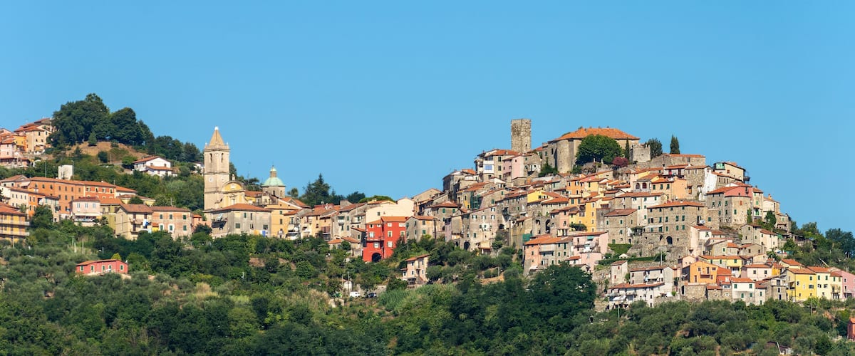 A hillside town with historic buildings and a prominent church tower.