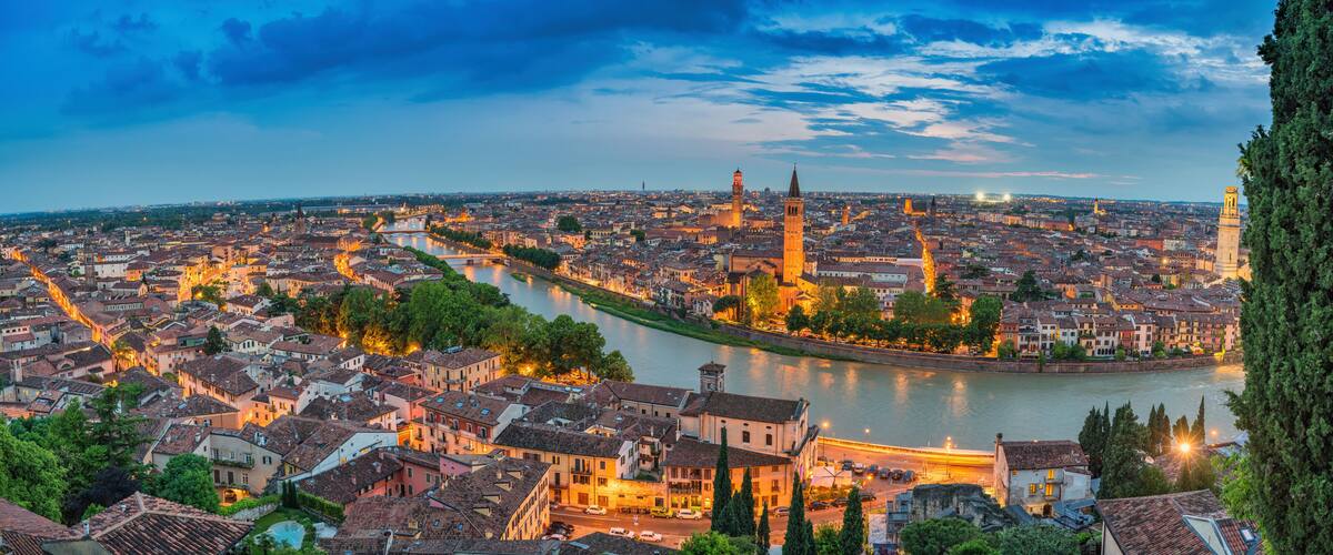 A panoramic view of a city with a river, historic buildings, and prominent towers.