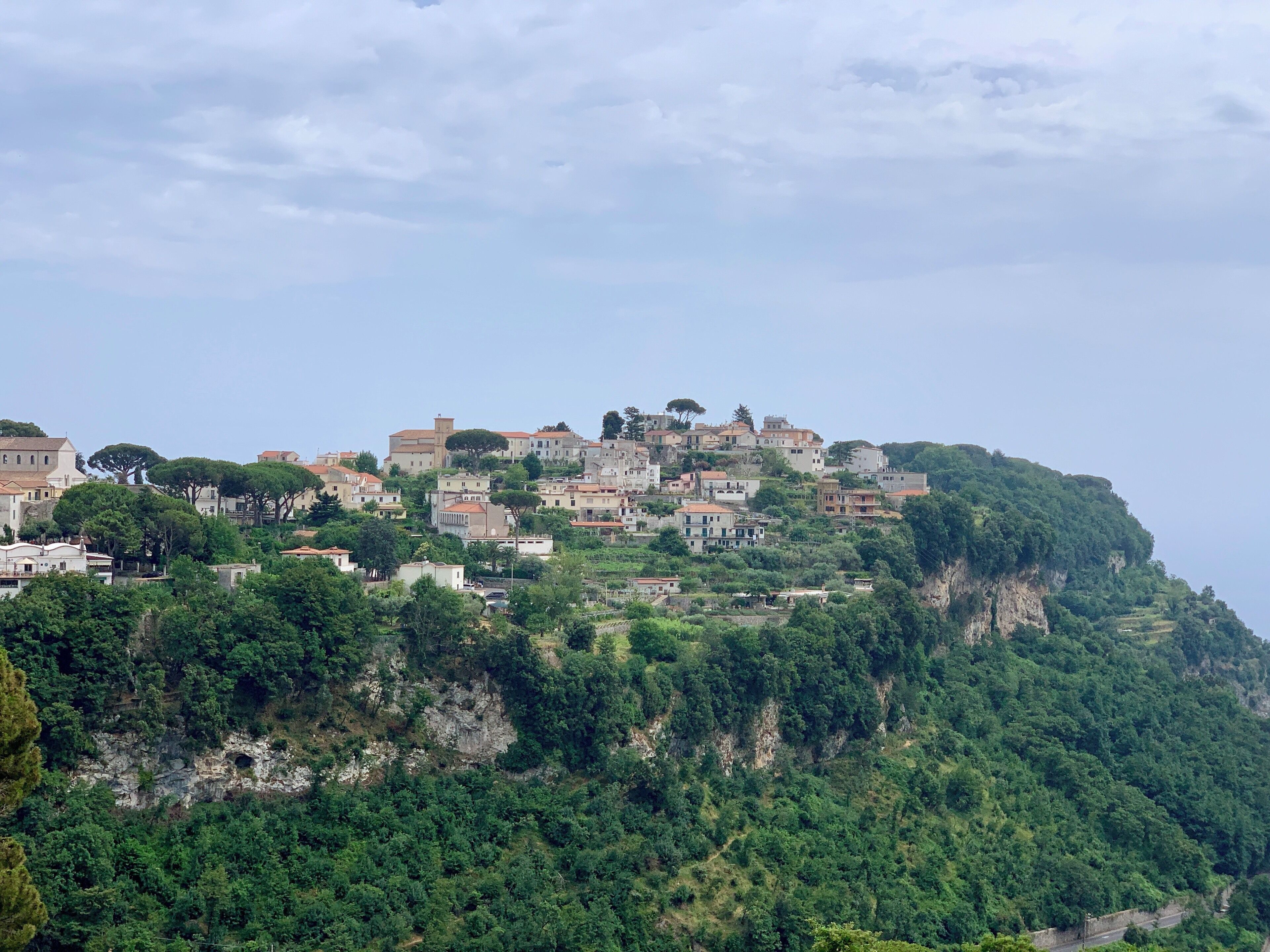 A hillside settlement with buildings and trees.