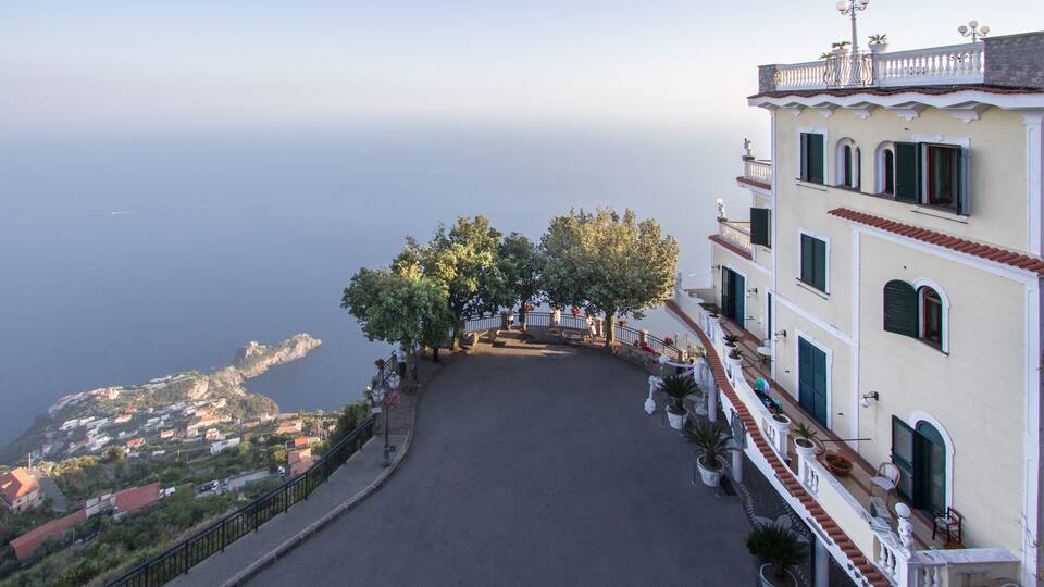 A coastal road with a view of the sea and a town in the distance.