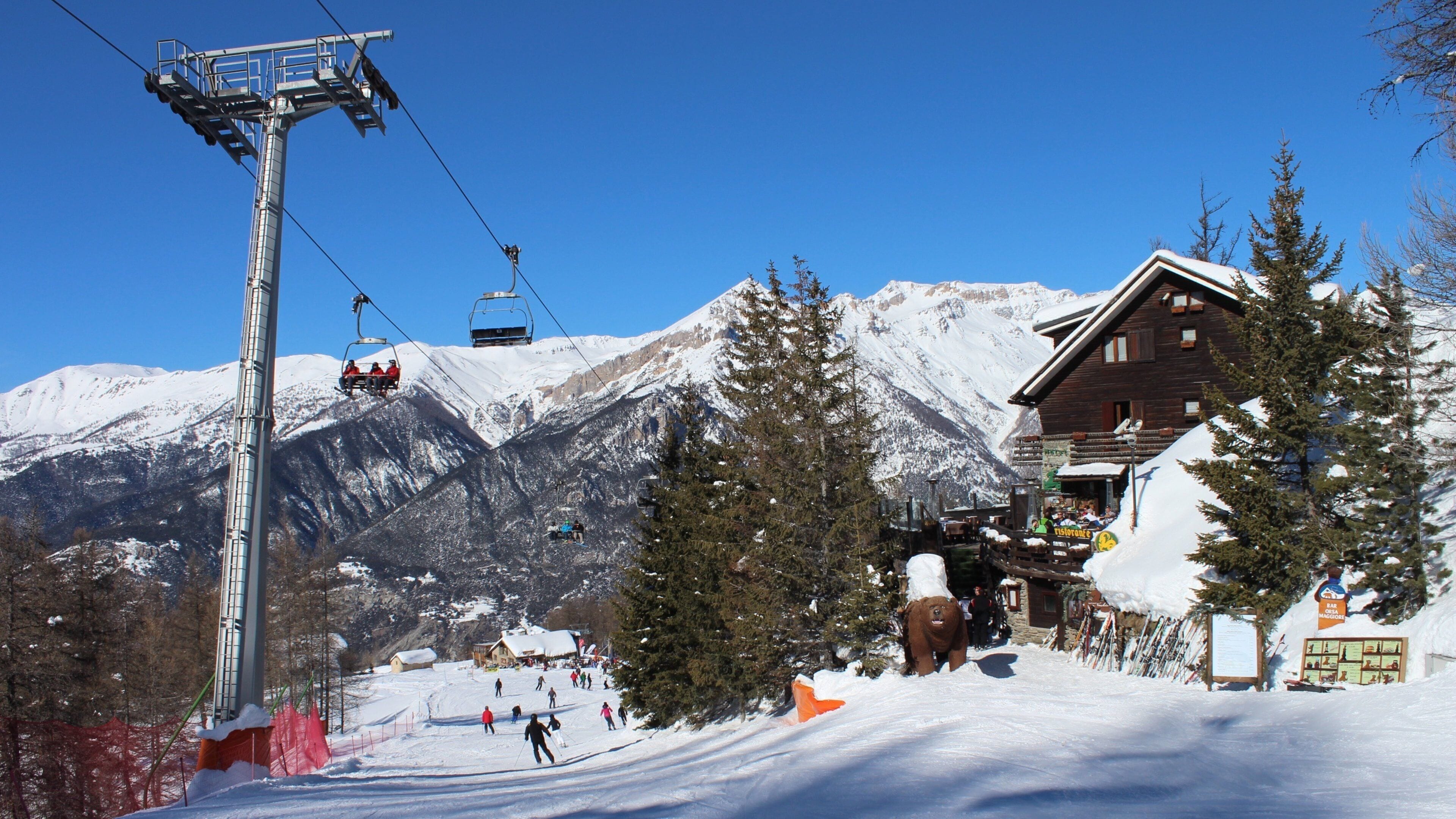 Sauze d\'Oulx som visar ett hotell, en gondola och snö