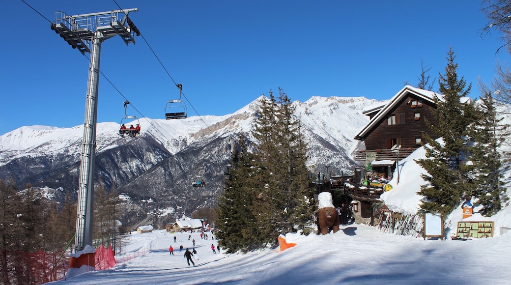 Sauze d\'Oulx som visar ett hotell, en gondola och snö