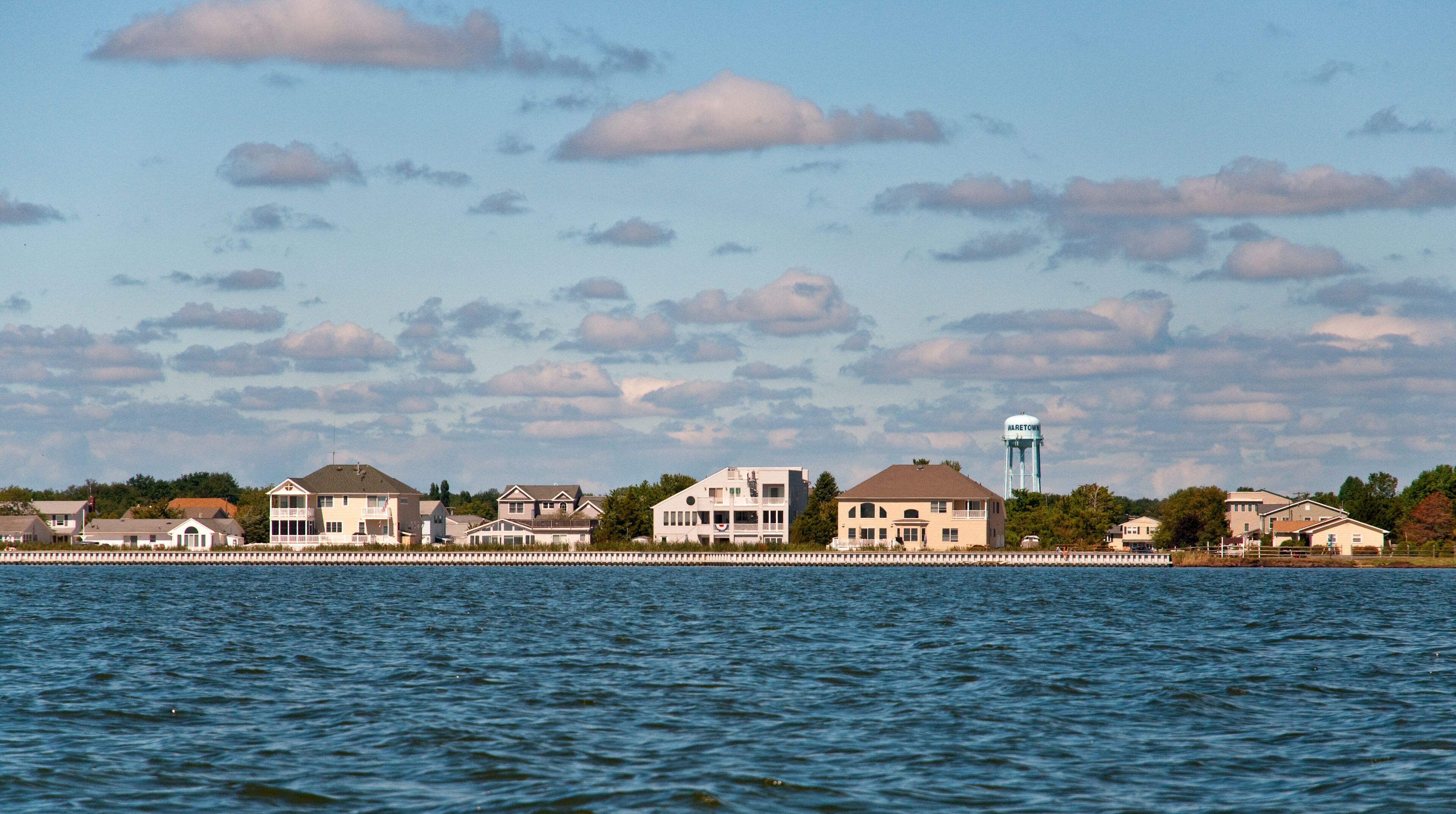 A waterfront with houses and a water tower.