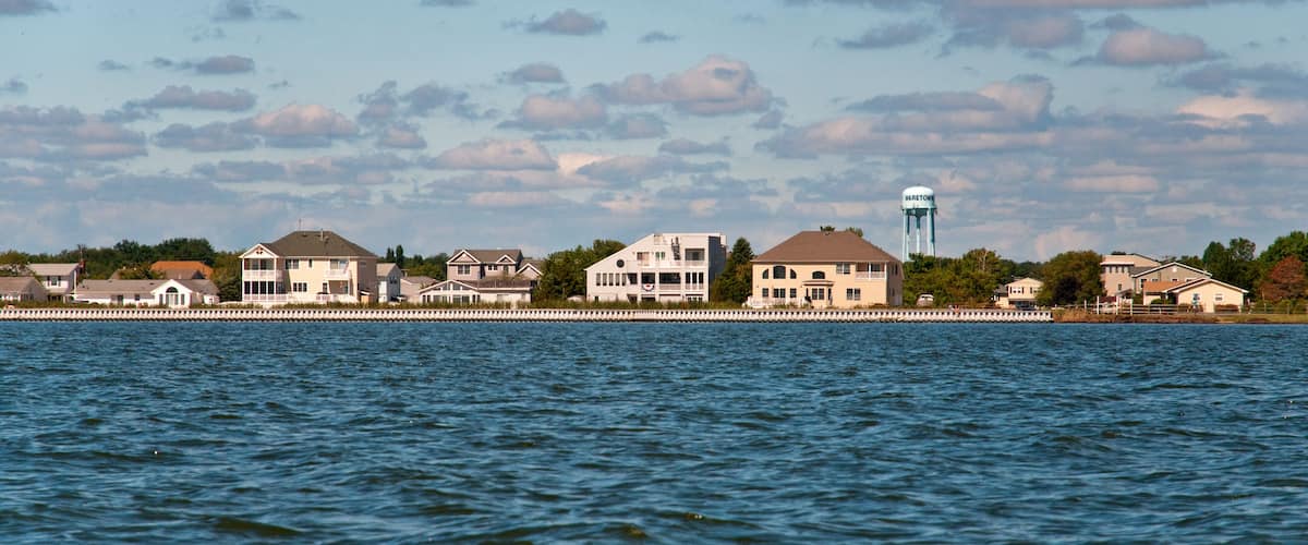 A waterfront with houses and a water tower.
