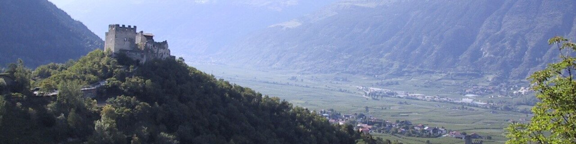 This media shows the cultural heritage monument with the number 15653 in South Tyrol. Der Felsenhügel am Eingang in das Martelltal im Vinschgau mit Ober- und Untermontani