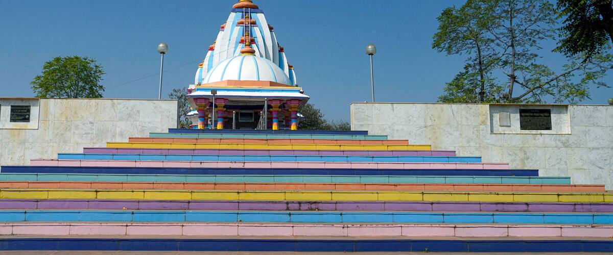 A temple with a colorful staircase leading up to it.