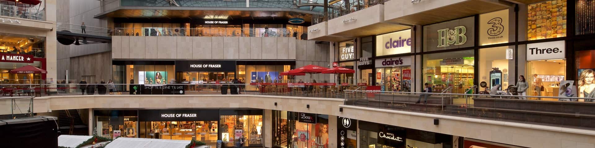 A multi-level shopping mall with various stores including House of Fraser, Claire's, and H&M.