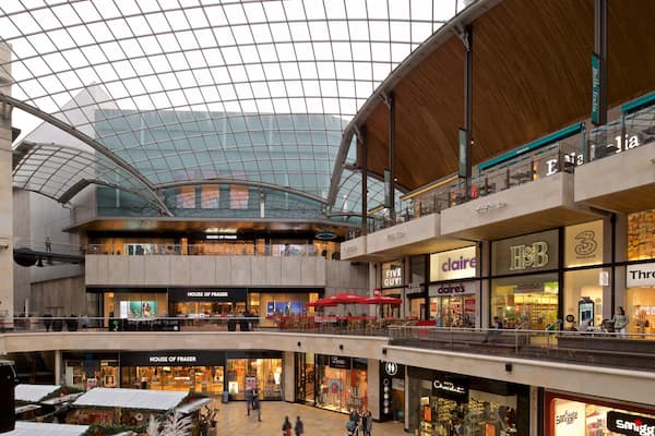 Ein mehrstöckiges Einkaufszentrum mit verschiedenen Geschäften, darunter House of Fraser, Claire's und H&M.