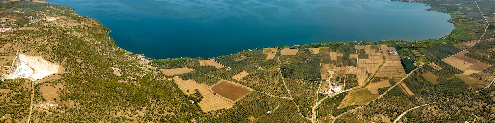 Panoramic aerial view of Varano Lake. It is a coastal lake located in the province of Foggia, in Gargano, Puglia, Italy. In the background is the Adriatic Sea.