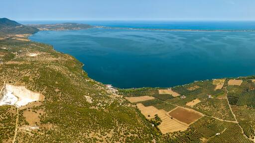 Panoramic aerial view of Varano Lake. It is a coastal lake located in the province of Foggia, in Gargano, Puglia, Italy. In the background is the Adriatic Sea.