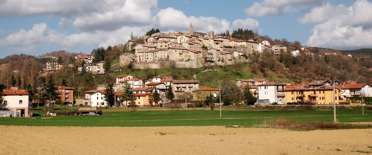 A town on a hill with buildings, a church, and a clear sky.