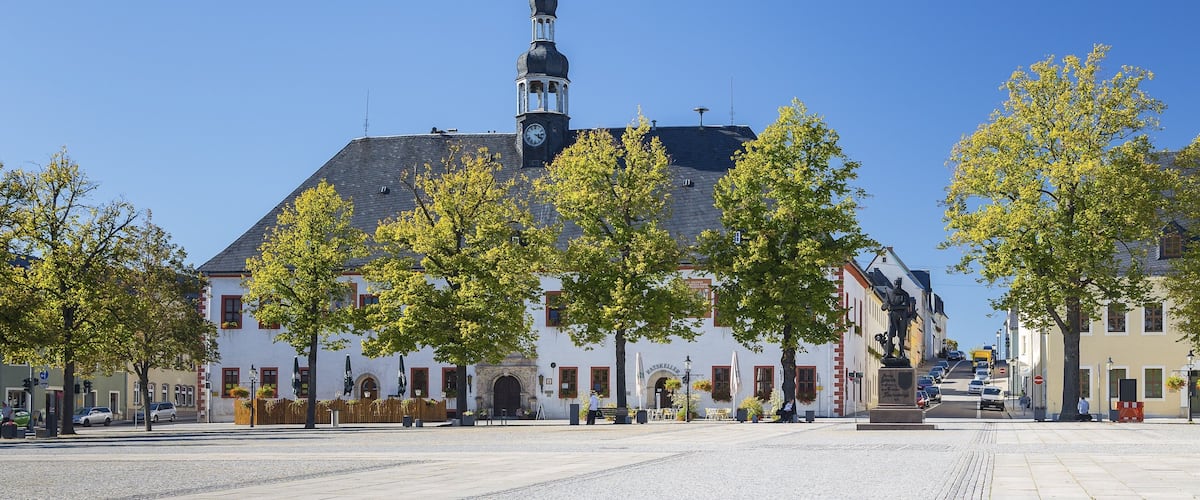 A town square with a prominent church, a statue, and surrounding buildings.
