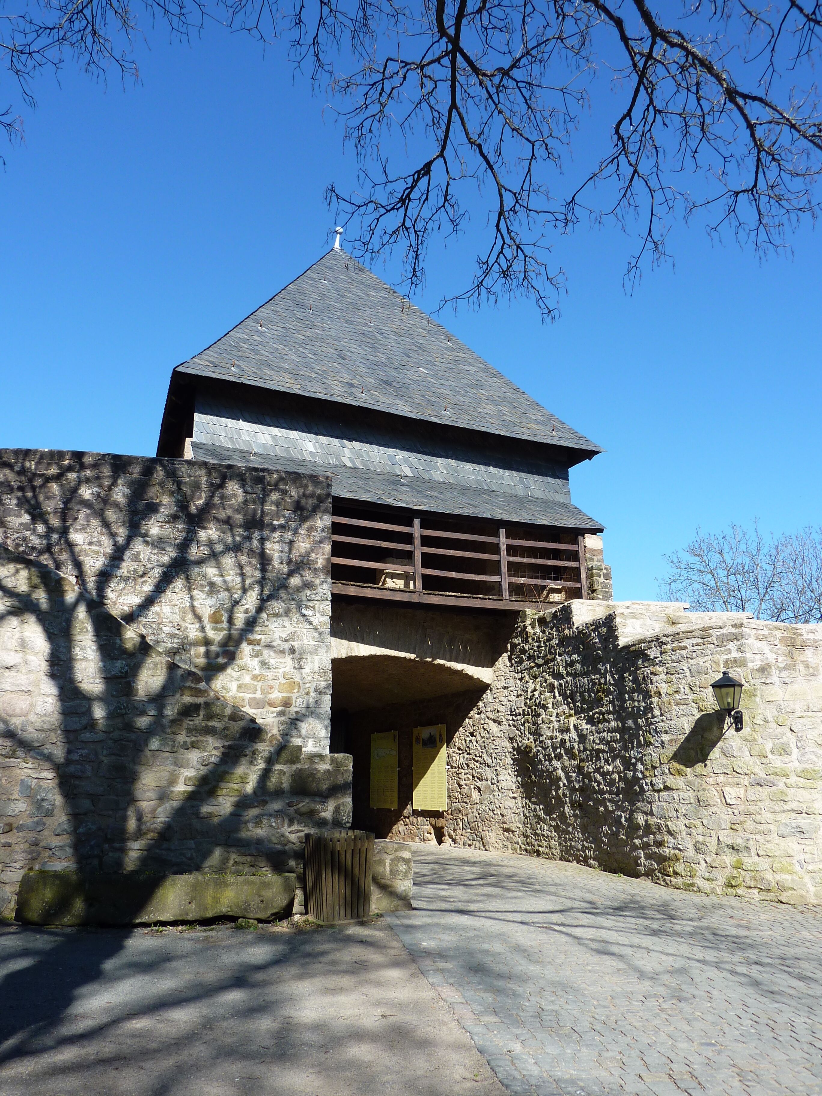 A stone building with a steep roof and a wooden balcony.