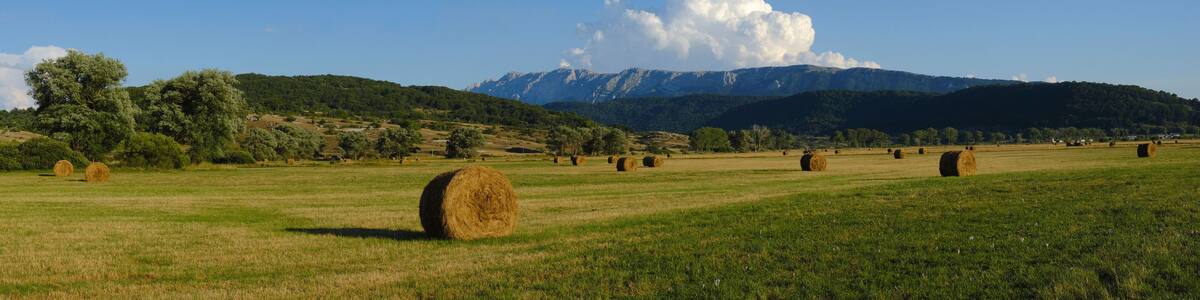 Rural fields with hay bales with mountains on the background at Rocca di Mezzo upland , Abruzzo , Italy