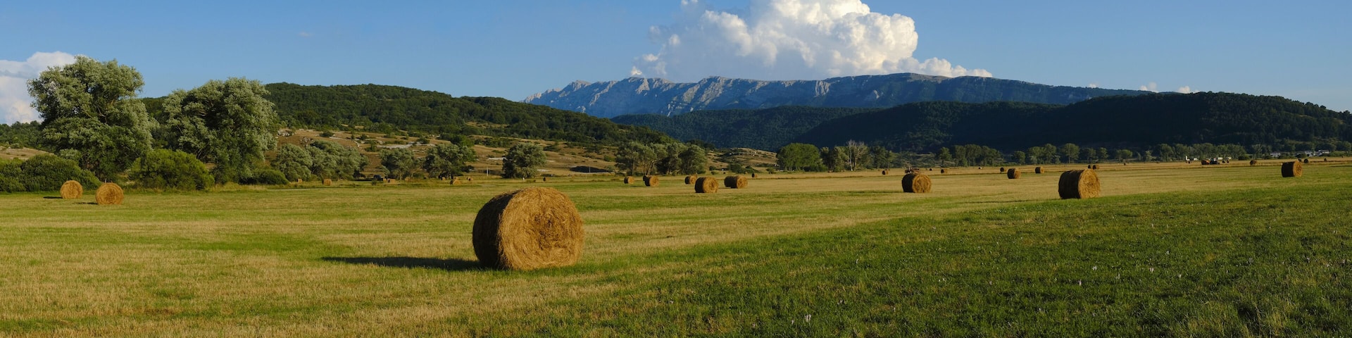 Rural fields with hay bales with mountains on the background at Rocca di Mezzo upland , Abruzzo , Italy