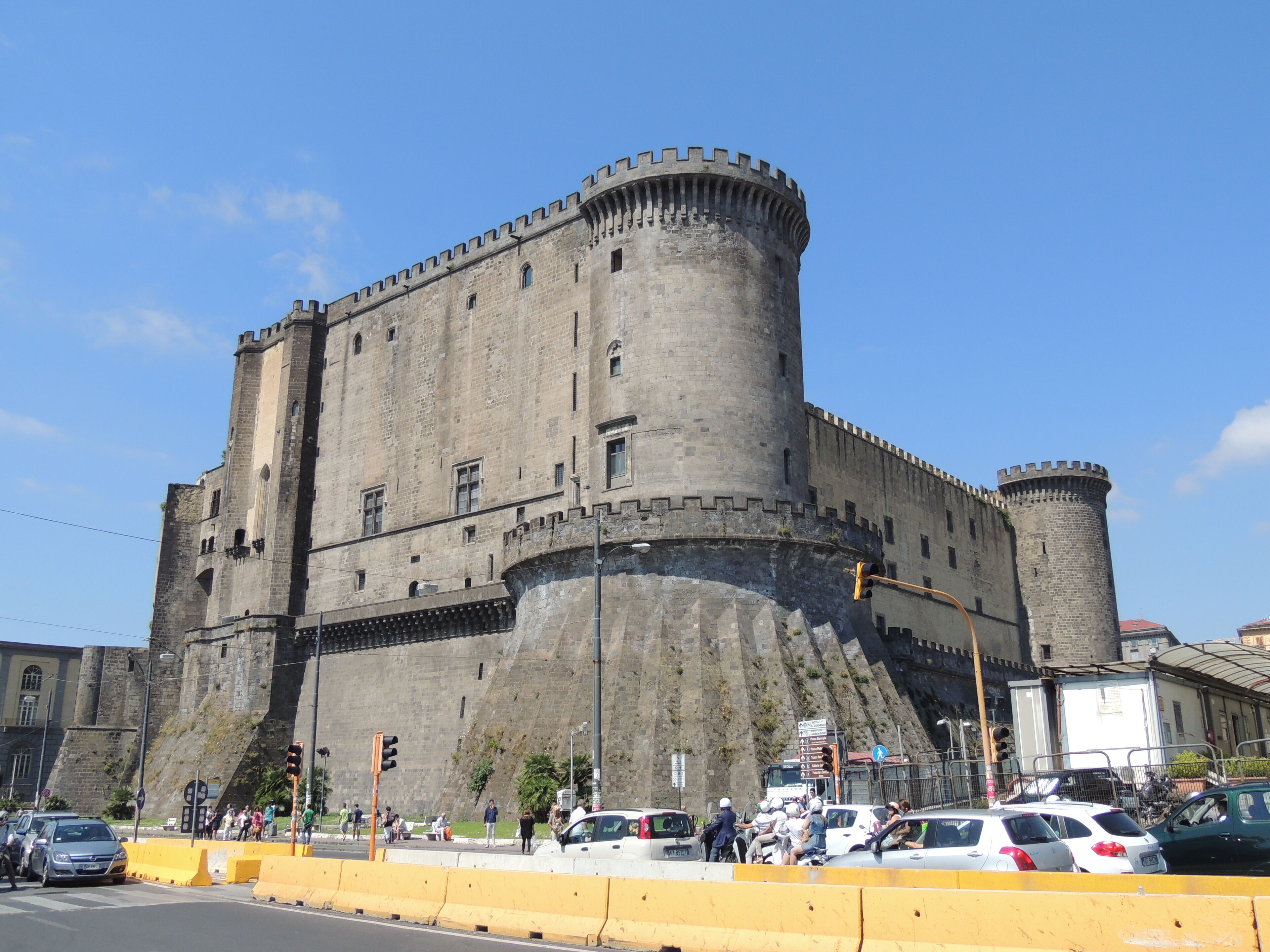 A historic castle with a large central tower and a surrounding wall.