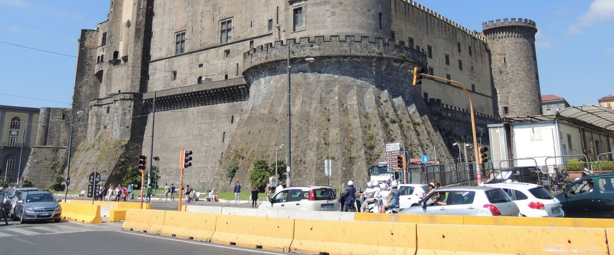 A historic castle with a large central tower and a surrounding wall.