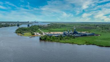 Aerial close up view of the North Carolina battleship from WWII permanently docked across from Wilmington NC historic downtown