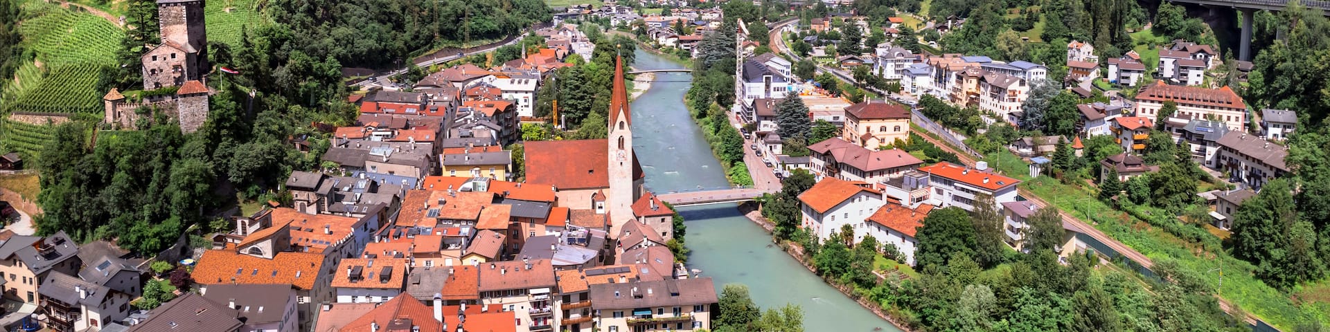 A town with a river, a castle on a hill, and a bridge.