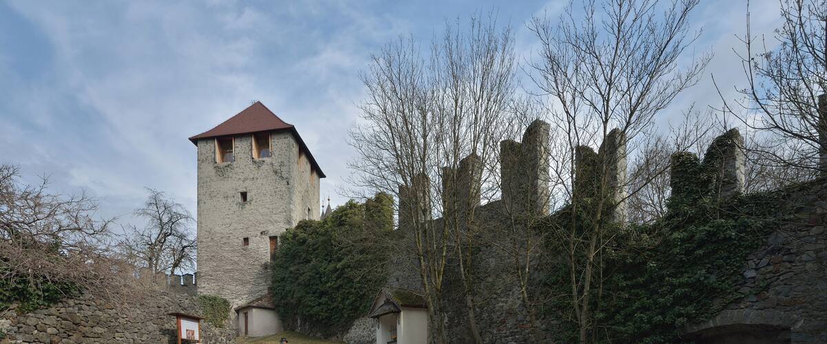 A stone tower, a stone bridge, and a path leading to a small building.