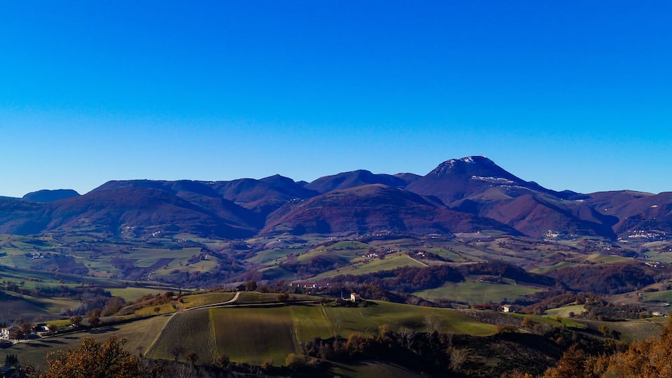 A mountainous landscape with rolling hills and scattered houses.