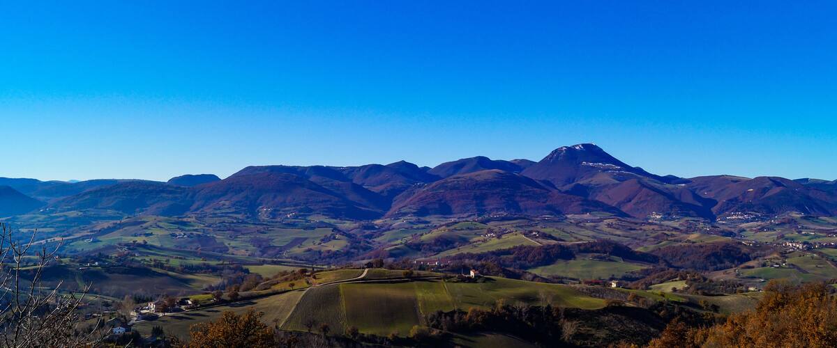 A mountainous landscape with rolling hills and scattered houses.