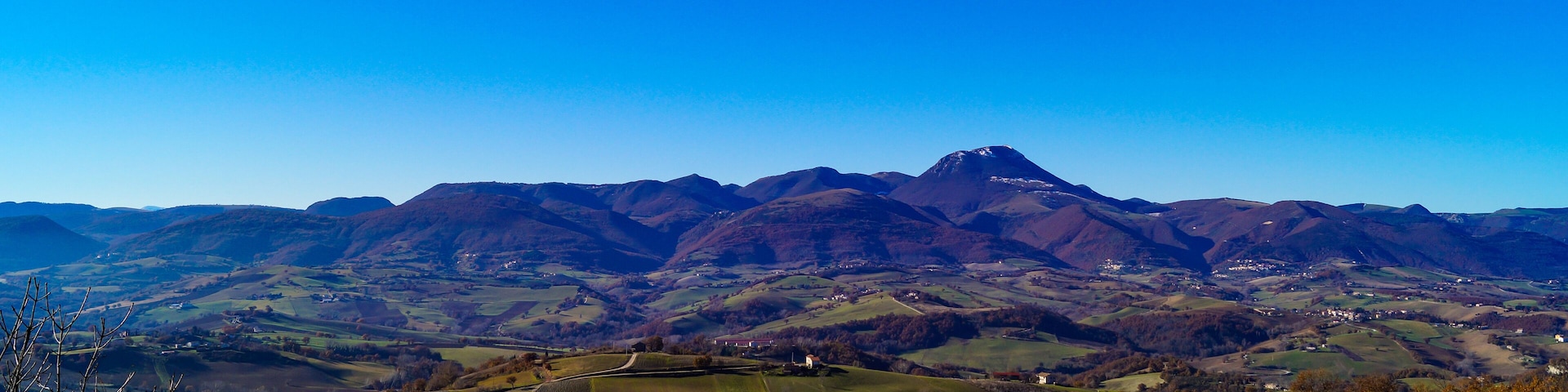 A mountainous landscape with rolling hills and scattered houses.