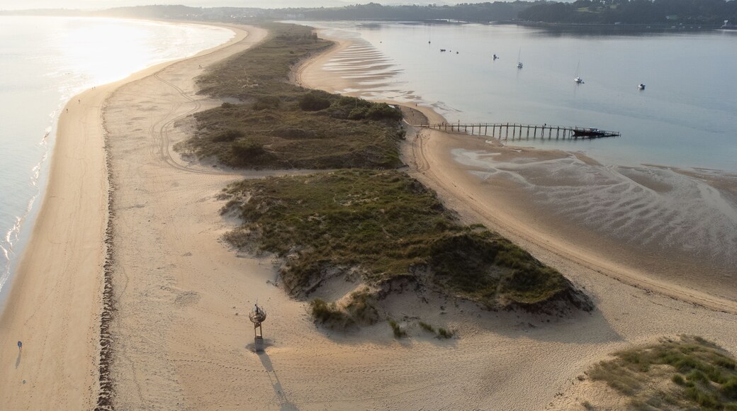 Early morning aerial view of El Puntal spit stretching into the distance with its empty sandy beach. Somo, Cantabria, Spain.