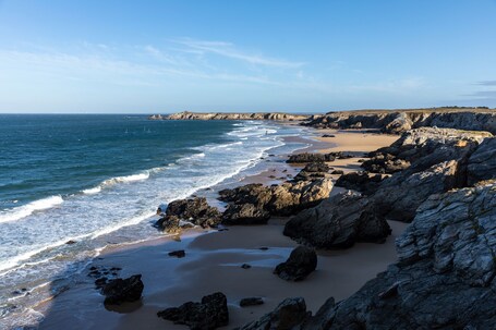 Une côte rocheuse où les vagues se brisent sur le rivage.