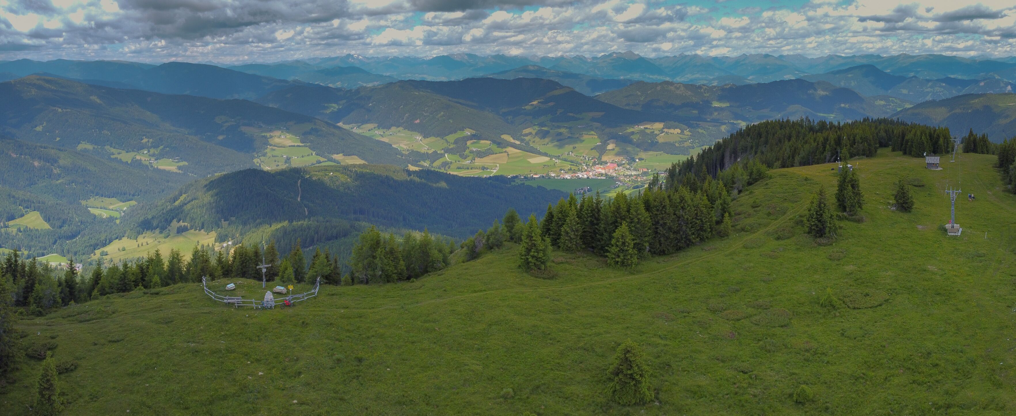 Wooden religious cross on the top of a hill in Austria. Grebenzen Dreiwald kogel close to Sankt Lambrecht ion a sunny and cloudy weather.