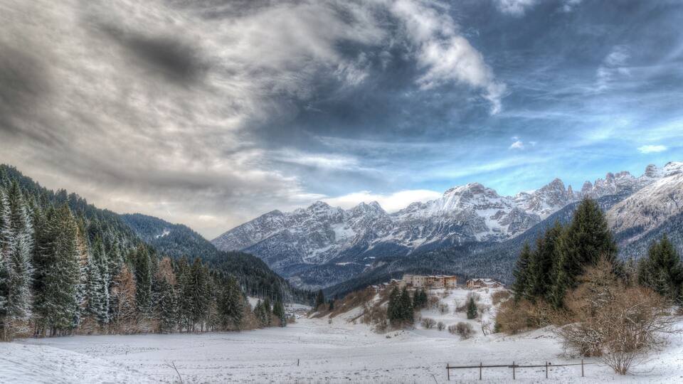 A snowy mountain landscape with a village in the valley.