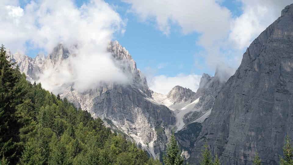 A mountainous landscape with dense forests and rugged peaks.