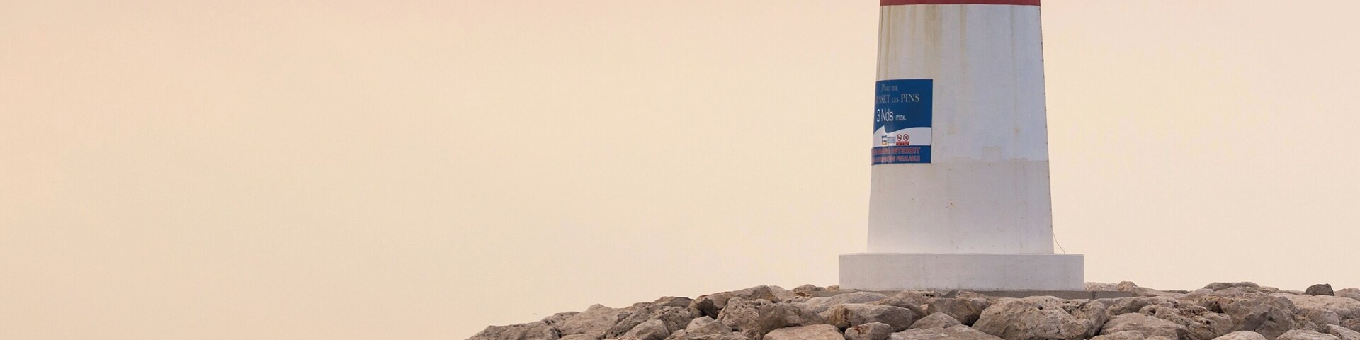 Un faro sobre un promontorio rocoso frente al mar.