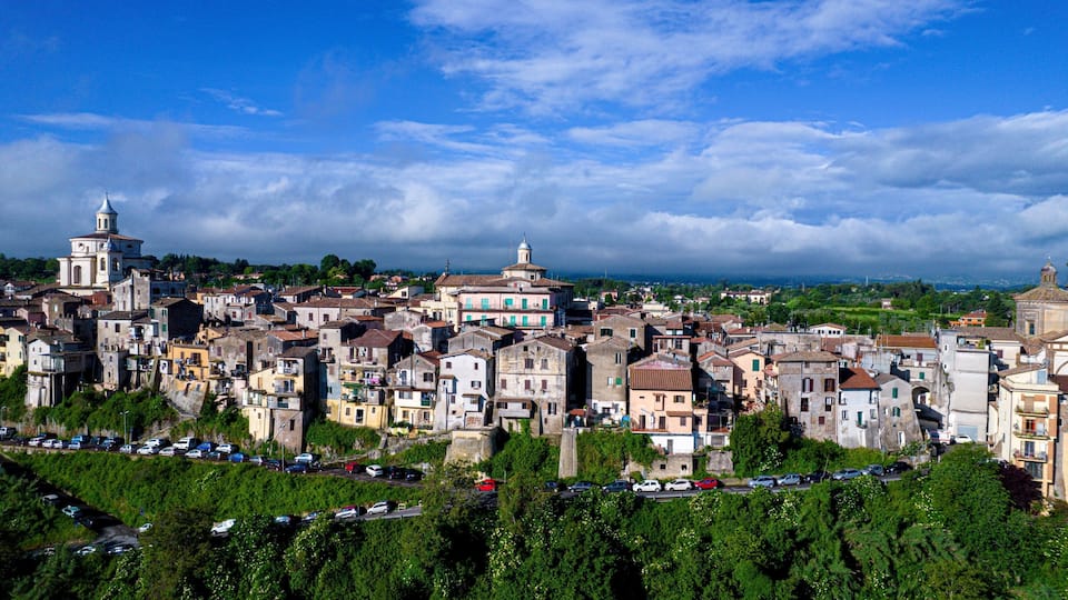 A densely packed historic town with varied architecture, including prominent domed buildings and narrow streets.
