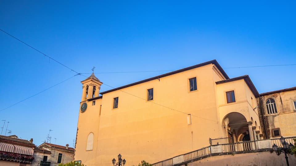 A yellow building with a clock tower and arched entrance.