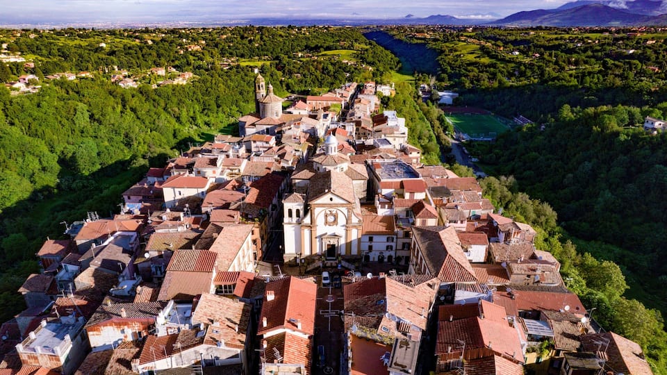 A town with a prominent church, terraced houses, and a river.