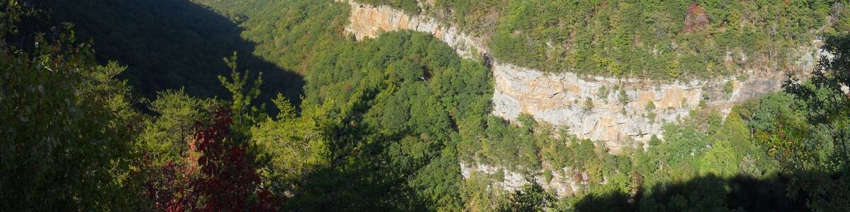 A mountainous landscape with dense forests and rocky cliffs.