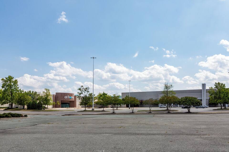 A parking lot with a building labeled "at home" and a large industrial building in the background.