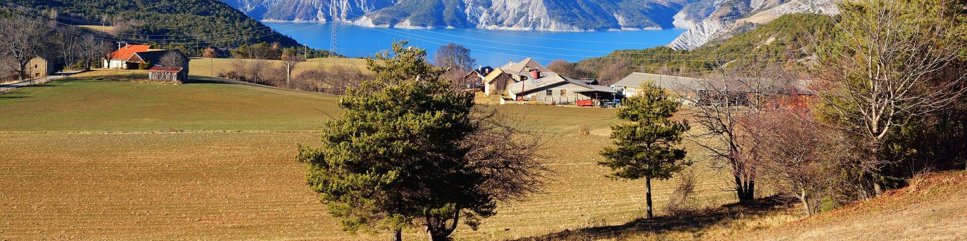A small village near lake Lac de Serre-Poncon in the french Alps on a sunny day. Ecrins massif
