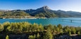 Summer panoramic view of Serre-Poncon Lake with Savines-le-Lac, its bridge and the Grand Morgon mountain peak. Hautes-Alpes, PACA Region, Southern French Alps, France