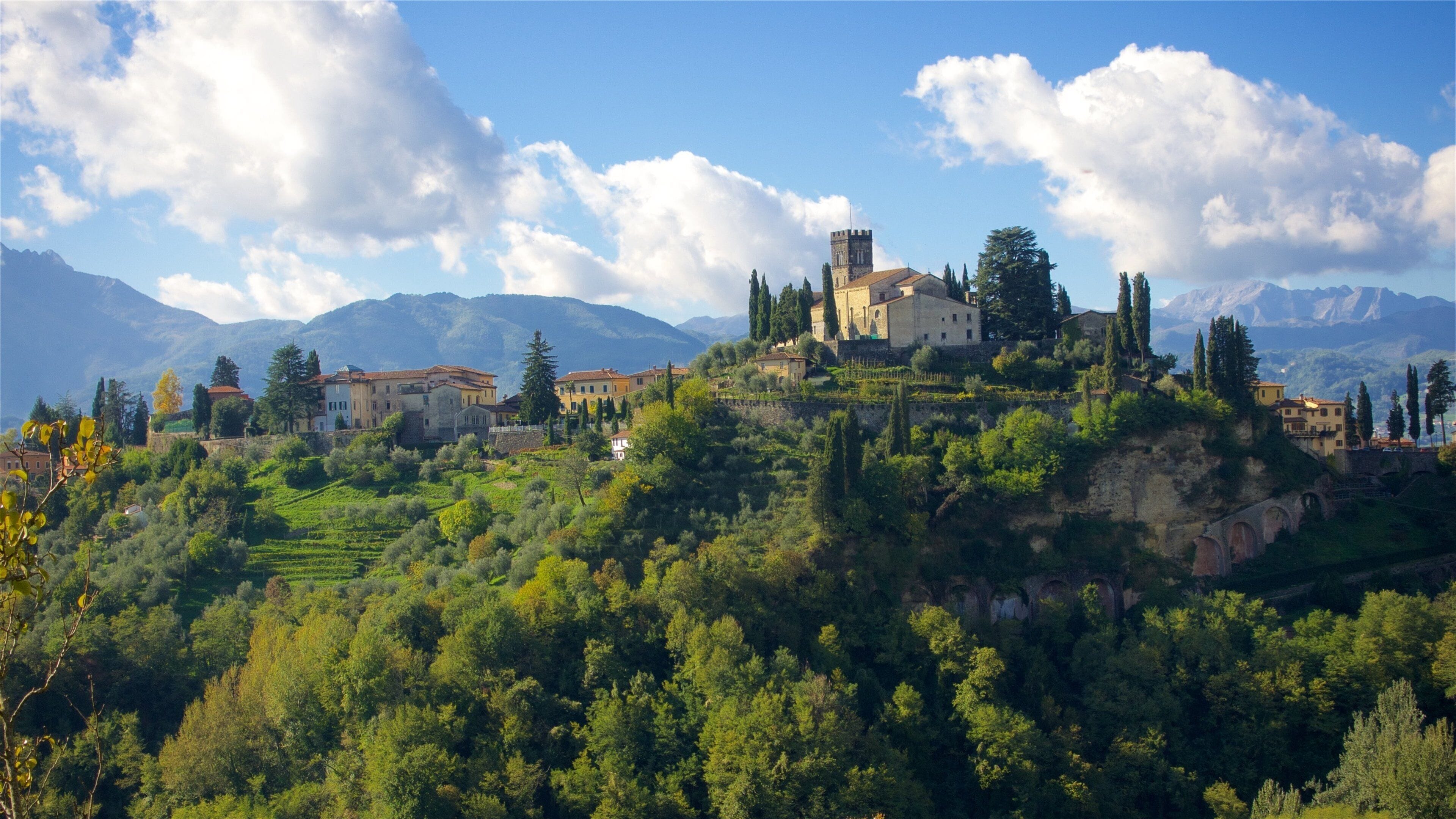 A hillside village with historic buildings and a prominent tower.
