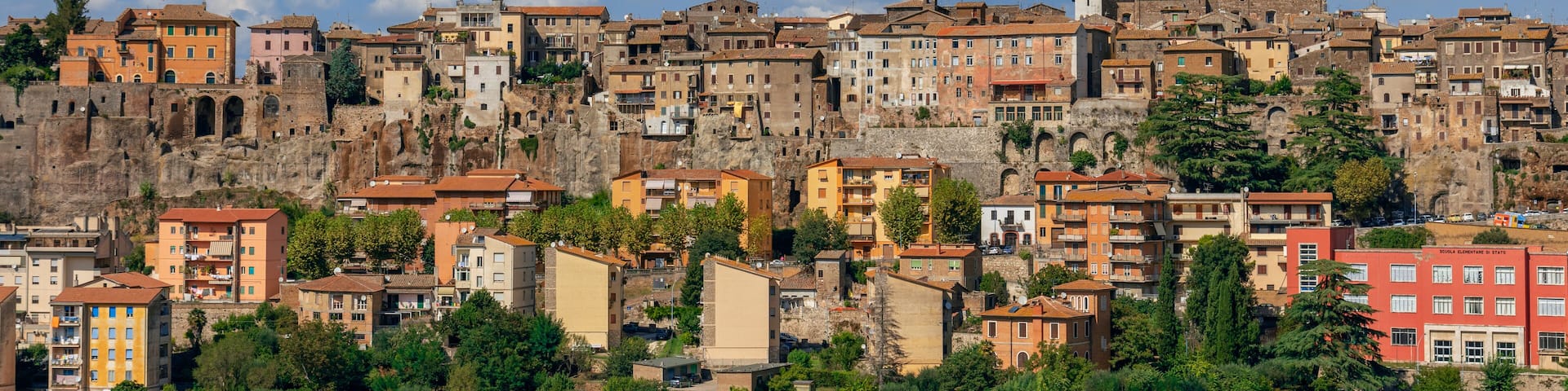 A historic town with colorful buildings, a prominent church, and a castle on a hill.
