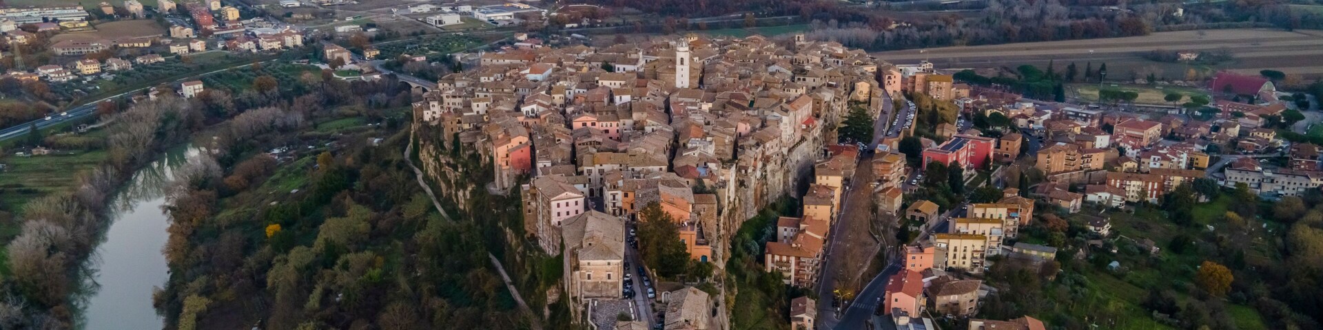 Vista aérea de un pueblo histórico con un río, edificios densos y colinas circundantes.